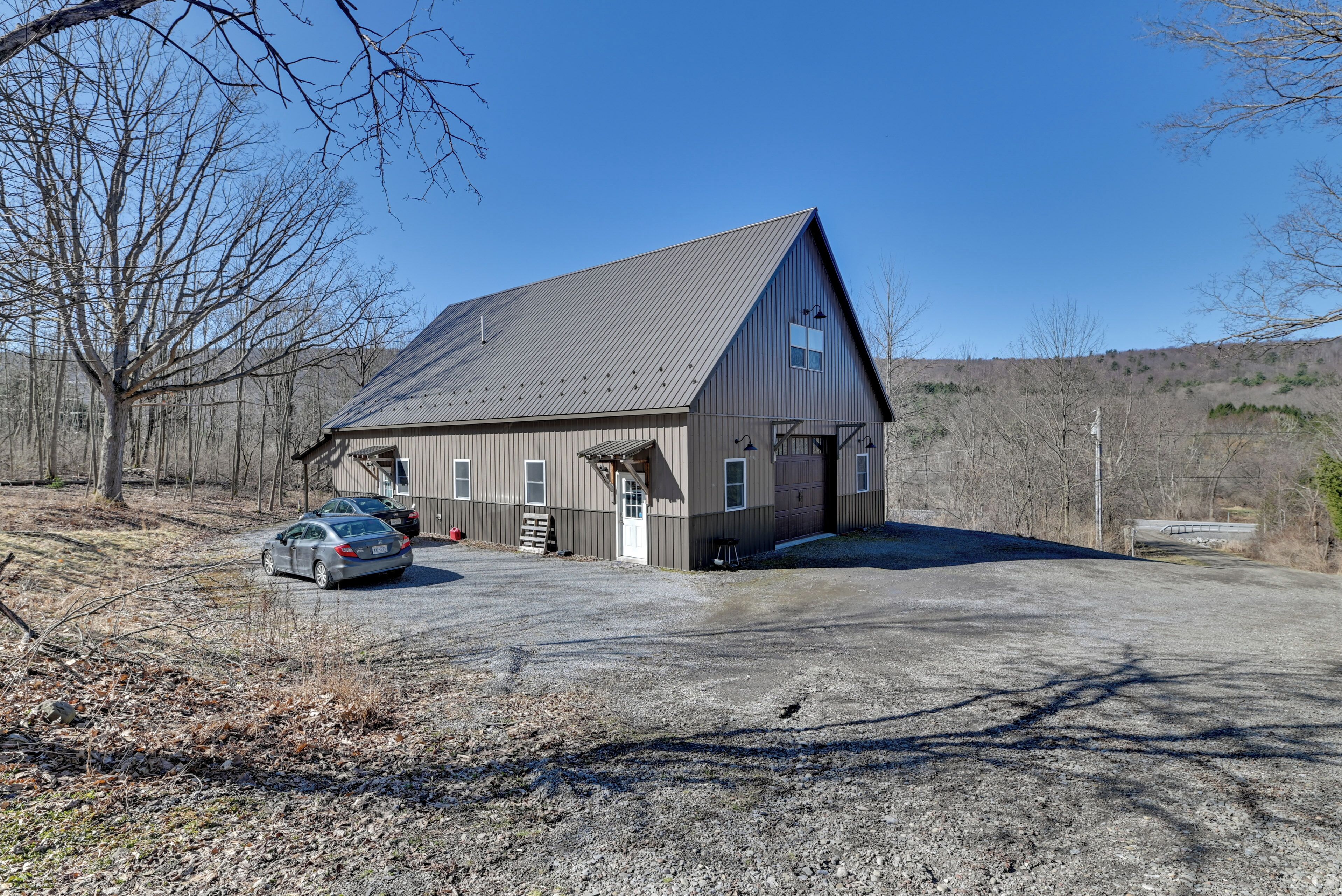A two-story building with a garage, a driveway, and a parking area.