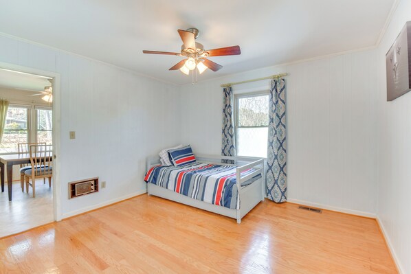 A bedroom with a bed, a ceiling fan, a window with curtains, and a wooden floor. - 4 Mi to Lake Hartwell: Welcoming Family Home (Hartwell)