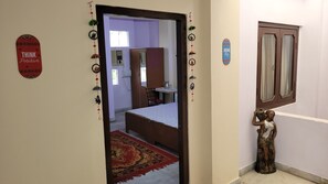 Enter a serene space with a comfortable bed, decorative wall hangings, and a motivational sign.