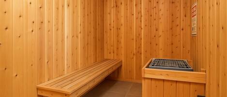 Una sala de sauna con paredes de madera, un banco y una mesa para sauna.