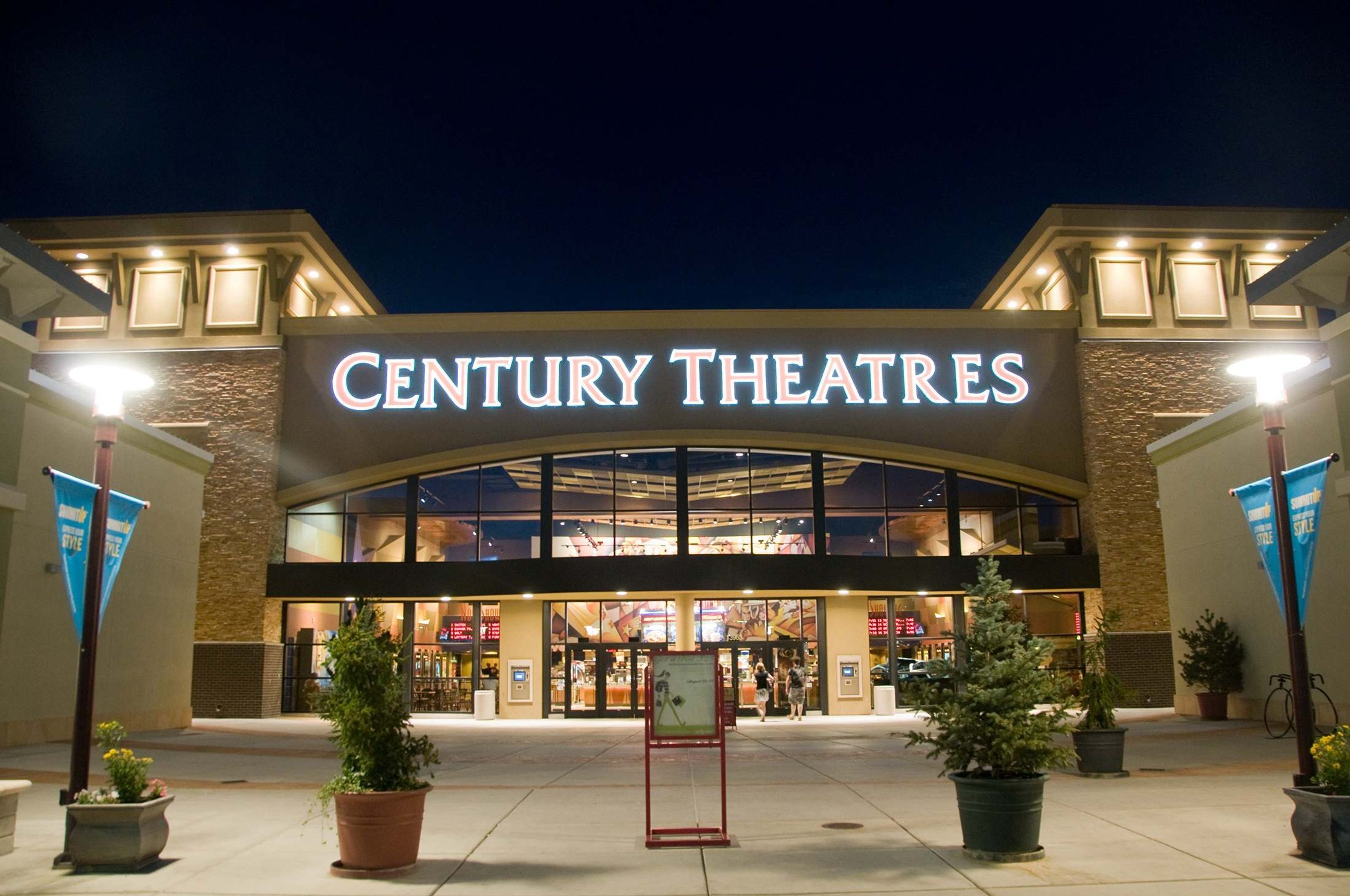 Century Theatres com fachada moderna, grande entrada e vasos de plantas na frente.