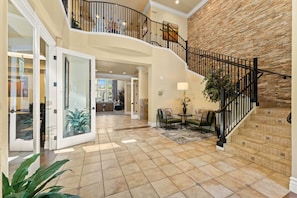 A spacious interior with a curved staircase, a dining area, and a view of the kitchen. - New Cozy Stylish 1BR With Heated Pool Relaxing Spa Sauna (Reno)