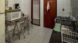 A compact kitchen with a microwave, stove, and small dining area.