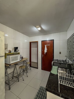 A compact kitchen with a microwave, stove, and small dining area.