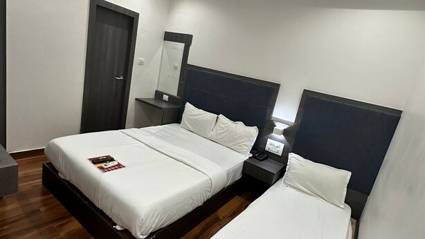 A modern hotel room with two beds, a ceiling fan, an air conditioning unit, and a wooden floor.
