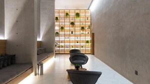 Ein modernes Interieur mit einer Sitzecke, einer Wandpflanzen-Anlage und einem klaren, minimalistischen Design.