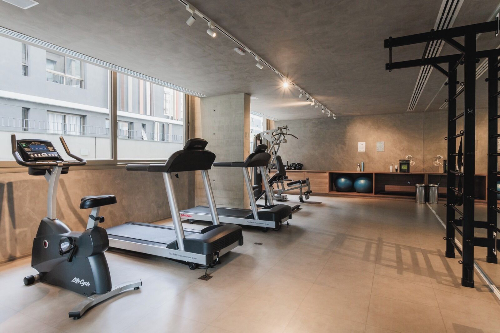 Une salle de sport équipée de tapis de course, d’un appareil elliptique et d’un banc de musculation.