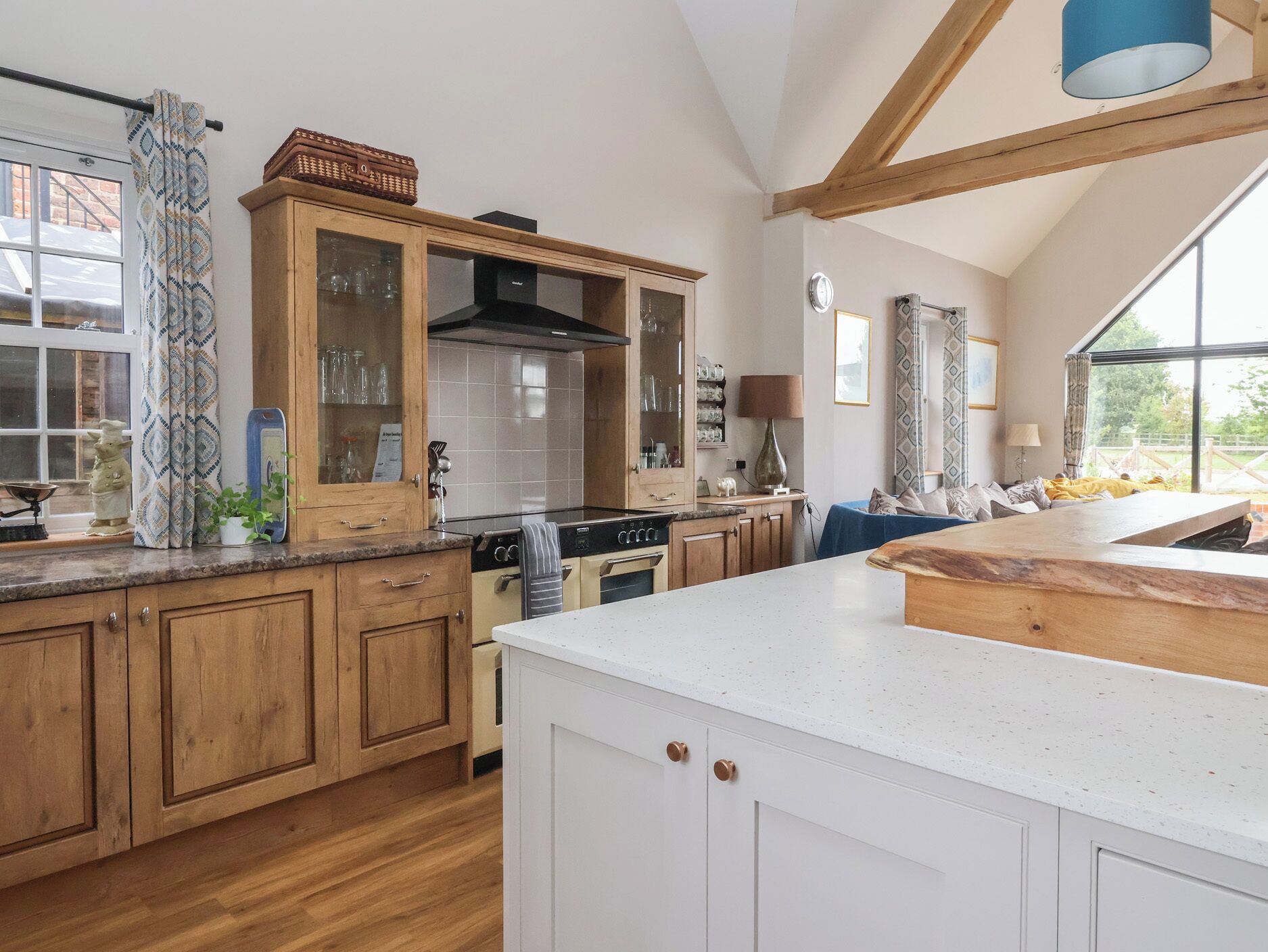 A spacious kitchen with wooden cabinets, a large island, and a view of the outdoors.