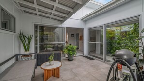 A modern patio with a seating area, potted plants, and a bicycle.