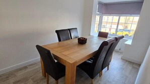A dining area with a wooden table and four black chairs. - Spacious Central Home - Sleeps 7, Garden & Parking (Sheffield)