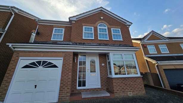 A two-story brick house with a white front door, a garage door, and a small porch. - Spacious Central Home - Sleeps 7, Garden & Parking (Sheffield)