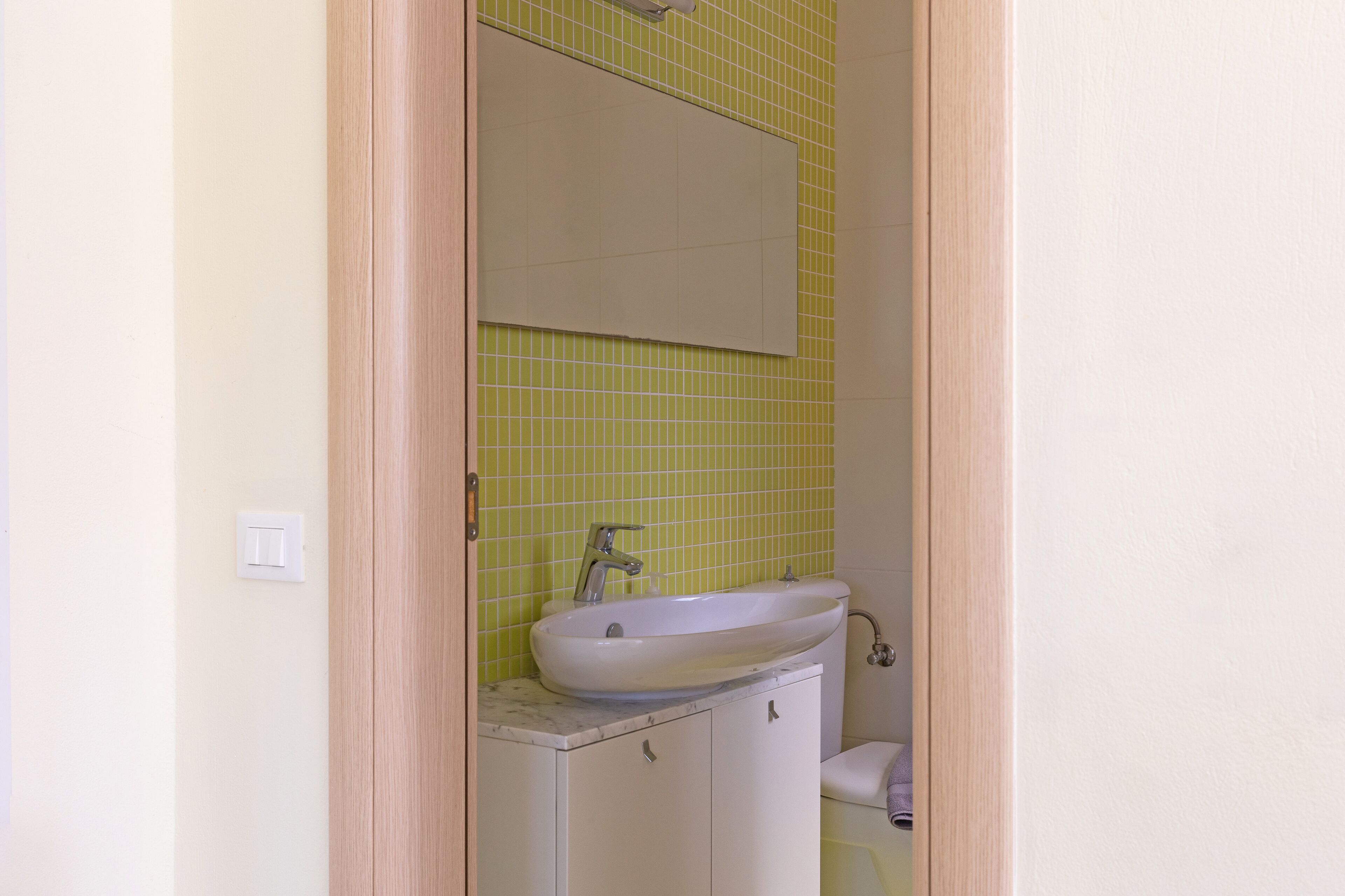 Ein Badezimmer mit Waschbecken, Spiegel und Toilette.