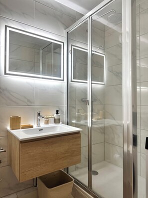 Regadera, secadora de cabello, toallas, papel de baño 