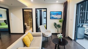 Una sala de estar moderna con un sofá, un sillón y una mesa de centro, un cuadro en la pared y vistas a través de una puerta de cristal.