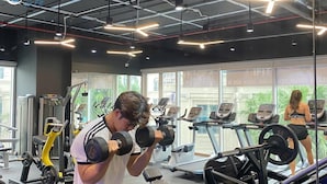 Un gimnasio con equipo de ejercicio, cintas de correr y máquinas de pesas.