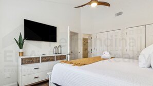 A bedroom with a bed, a TV mounted on the wall, a ceiling fan, and a wardrobe. - 2585 Forest Ridge 2 Bedroom Condo (Fernandina Beach)