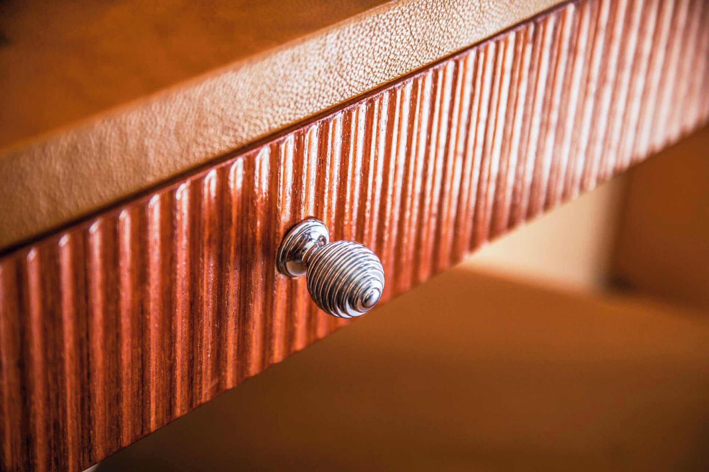 Un gros plan d’une surface en bois présentant un motif texturé et un bouton métallique.