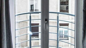 A view through a window with a metal railing, looking at a building with multiple windows and balconies. - Charming Apartment - 1br-4p- Geneva (Geneva)