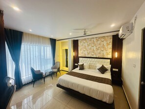 Relax in a spacious room with a large bed, tufted headboard, and comfortable seating area.