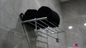 A bathroom with a towel rack holding two towels.