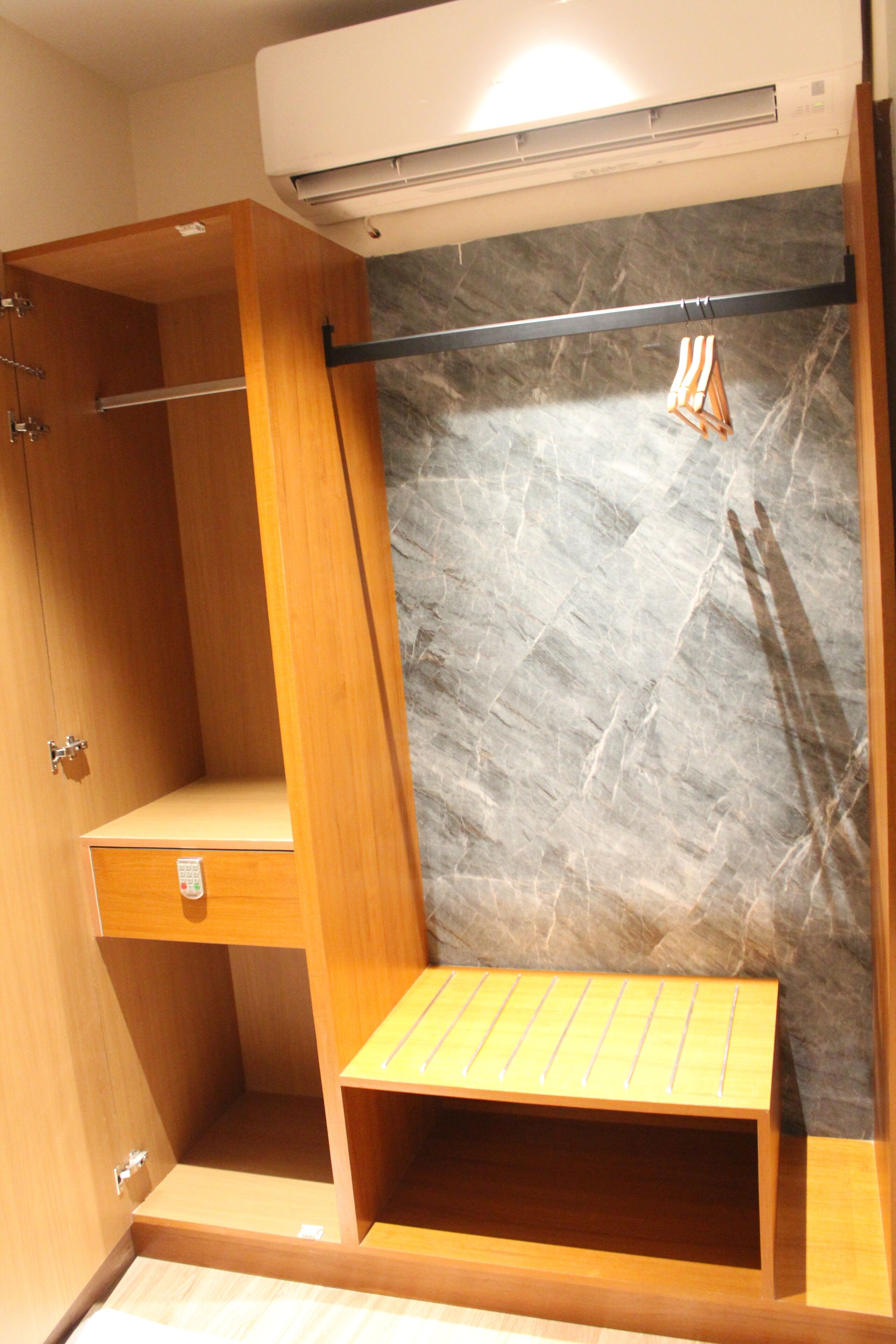 Ein Badezimmer mit einem Holz-Waschtisch, einem Handtuchhalter und einer Marmorwand.