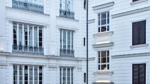 A multi-story building with white exterior walls, multiple balconies with black railings, and evenly spaced windows. - Il Papero a Napoli (Naples)