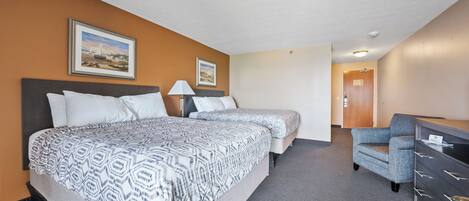 Een hotelkamer met twee bedden, een bureau en een stoel.