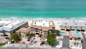 Un hotel sul lungomare con vista sulla spiaggia, diversi edifici e un’area parcheggio.