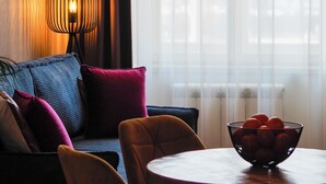 A cozy seating area with a sofa, chairs, and a table with a bowl of fruit. - Rašínovo nábřeží - Riverside Residence (Prague)