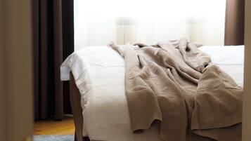 A bedroom with a bed, a rug, and curtains.
