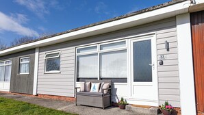 A mobile home with a grey exterior, a white door, and a number "55" on the side.