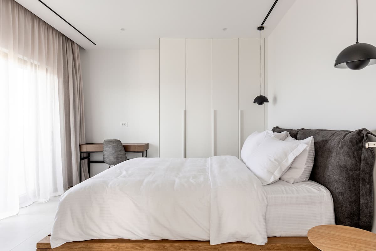 Ein modernes Schlafzimmer mit Bett, Schreibtisch und Kleiderschrank.