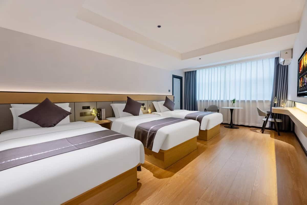 Una habitación de hotel con dos camas, un escritorio y una silla.