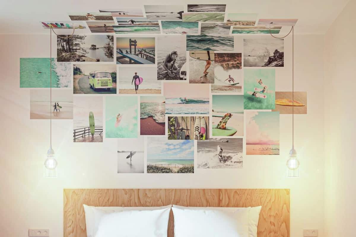 Een slaapkamer met een bed, een geruite vloer en een muur versierd met verschillende foto’s.