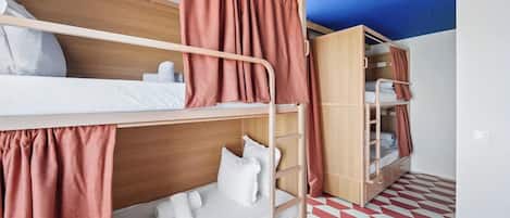 Habitación con literas, cabecera de madera, armario y suelo estampado.