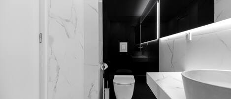 A modern bathroom with a marble floor, a white sink, and a toilet.