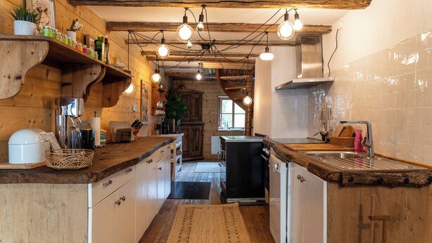 Une cuisine avec des meubles de rangement en bois, un évier et une cuisinière.