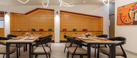 A modern dining area with a long table set for six, surrounded by chairs.