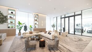 Amplia sala de estar con sofá seccional, dos sillones, una mesa de centro y un ventanal con vistas a la ciudad.