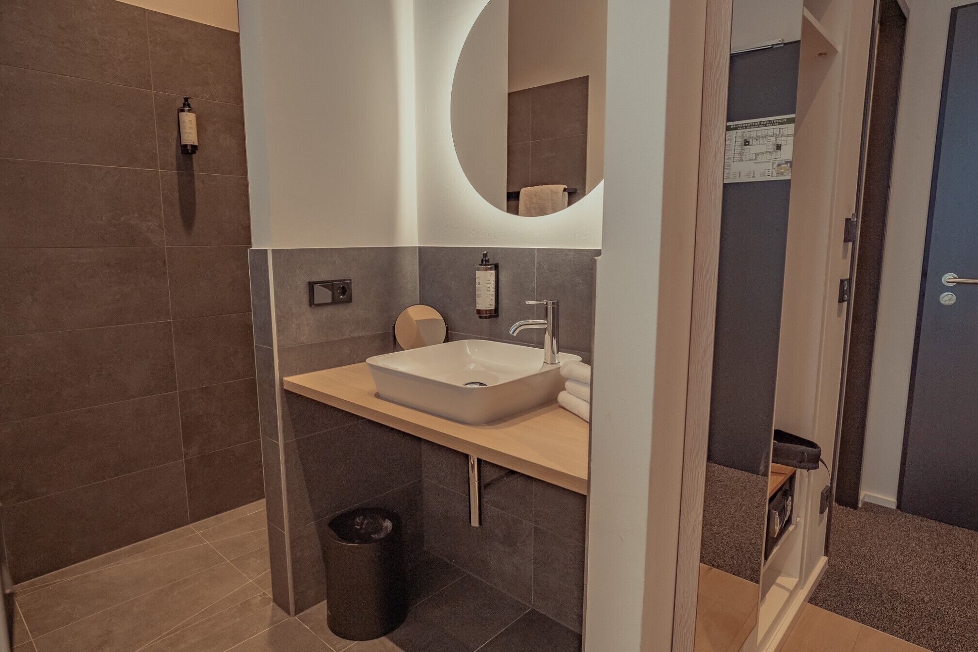 Un baño moderno con un lavamanos grande, un espejo y un inodoro.
