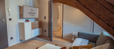 Une chambre de style loft moderne avec un plafond en pente, un bureau intégré, un canapé et un tableau encadré au mur.