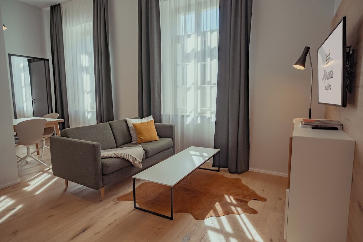 A modern living room with a grey sofa, a white coffee table, and a cowhide rug.