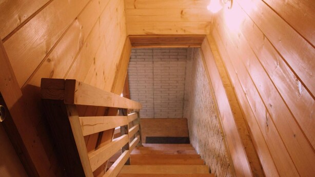 A wooden staircase leading to a brick wall. - Charming 2-bedroom cabin with AC, WiFi in brilliant Cisco Ga.  (Cisco)