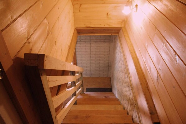 A wooden staircase leading to a brick wall. - Charming 2-bedroom cabin with AC, WiFi in brilliant Cisco Ga.  (Cisco)