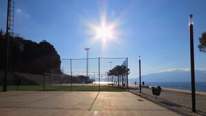 An empty sports field with a clear view of the sea and mountains in the background. - Balcony Studio • Outdoor Kitchen • Uji i Ftohtë (Vlora)
