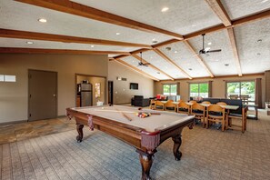 A pool table in a spacious room with a high ceiling and wooden beams, a seating area with tables and chairs, and a view of greenery outside. - Tranquil Lake Retreat w/ Hot Tub & Games (Oakland)