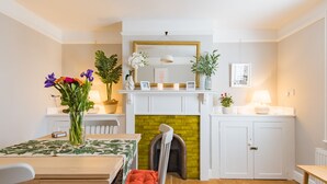 A modern kitchen with a white mantel, a yellow brick fireplace, and a white cabinet with a mirror above.
