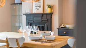 A dining table set with plates, glasses, and cutlery, surrounded by white chairs. - Seaclusion - Walmer, Deal (Walmer)