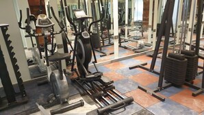 A gym with various exercise equipment, including treadmills, weight machines, and free weights. - hotel suncity palace (Katihar)