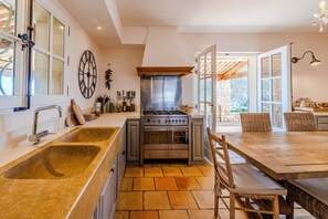 Una cocina con una isla grande, pileta doble y electrodomésticos de acero inoxidable.